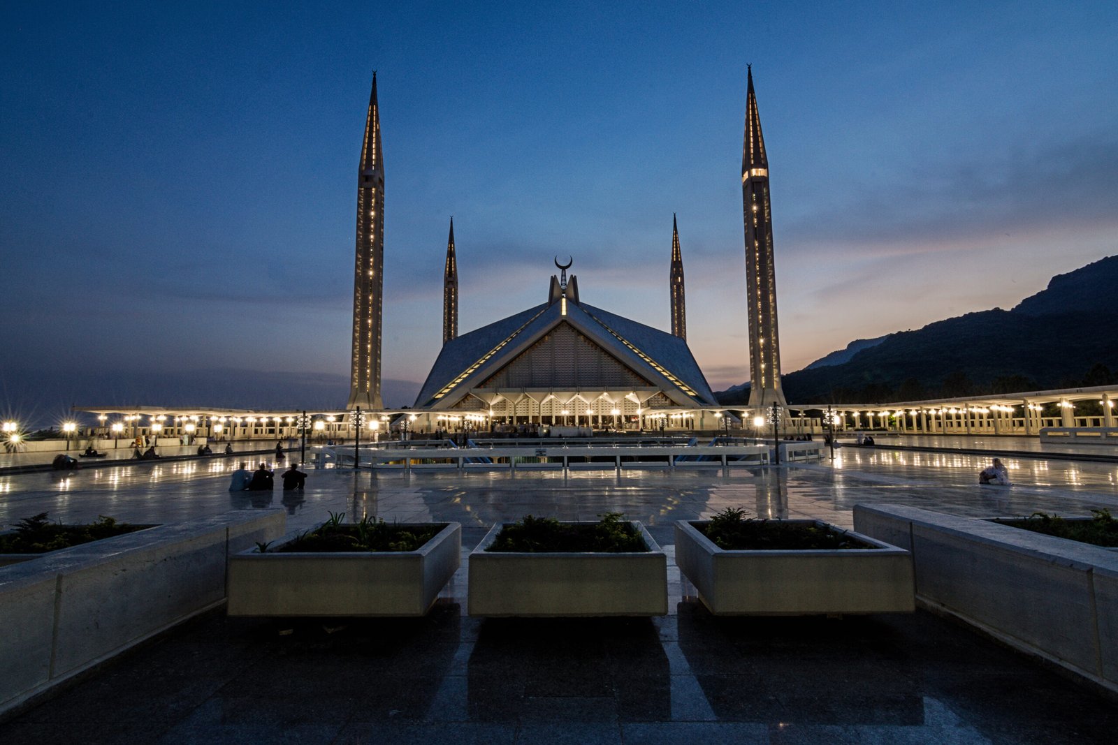Faisal Mosque in Islamabad at blue hour, backed by the Margalla Hills